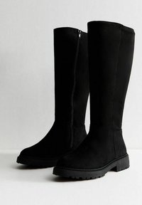 Czarne wysokie botki z miękkiego materiału przypominającego zamsz, z bocznym zamkiem błyskawicznym, okrągłym noskiem oraz wytrzymałą gumową podeszwą zapewniającą przyczepność.