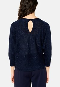 Navy blue sweater with a textured knit, featuring three-quarter sleeves and a keyhole detail at the back. Sparkly accents throughout.