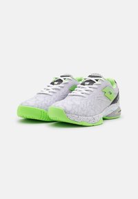 Adidași albi cu accente verzi, suprafață superioară texturată și un design cu modele; detalii gri și o talpă intermediară mărginită.