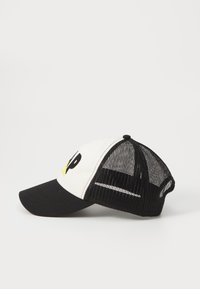 Mustvalge trucker-kork, millel on kõver visor, võrgutagune ja tikandiga kiri. Esiküljel on kollane aktsent.