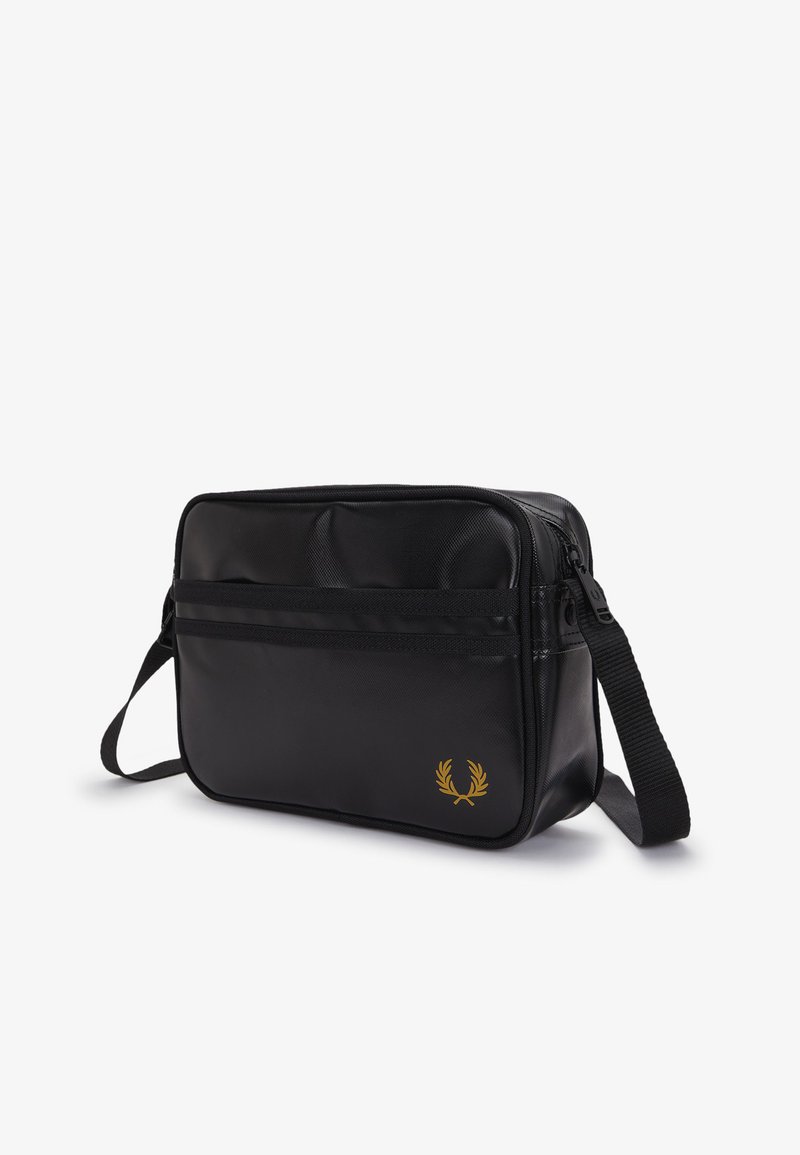 Sac d'épaule rectangulaire noir avec logo laurier doré, poche avant zippée et sangle ajustable sur fond blanc.