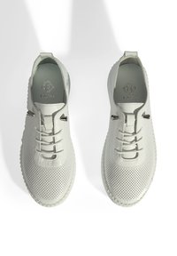 Baskets perforées blanches avec une tige en cuir texturé, bout rond, design à lacets et accents en métal. Semelle légère avec un bord à motifs.