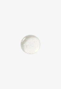 Goccia di gel trasparente con piccole bolle d'aria sospese all'interno, su uno sfondo bianco uniforme, centrata nel fotogramma.