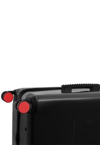 Black wheeled suitcase featuring red accent wheels, textured handle, and Lego logo. Smooth, durable surface with a modern rectangular design.