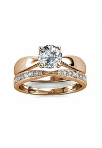 Roze gouden ringenset met een ronde, heldere centrale steen en een gladde band, versierd met kleinere heldere stenen aan één zijde.