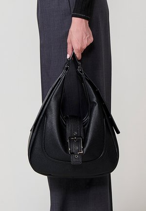 Bolso hobo de cuero negro con un acabado texturizado, que presenta una correa ancha, un distintivo detalle de hebilla y una silueta curva.