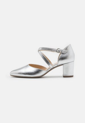 Silver metallic high heel shoe with a pointed toe, adjustable crisscross strap, and a block heel. Smooth texture and polished finish.