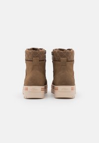 Brown suede ankle boots with a quilted fabric collar, featuring a light tan rubber sole and subtle orange stripes on the heel.