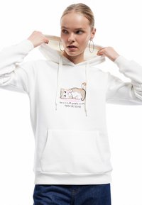 Biała bluza z kapturem wykonana z miękkiego materiału, z kolorowym, zabawnym wzorem kota w pastelowych odcieniach oraz tekstem poniżej. Posiada przednią kieszeń i regulowany kaptur.