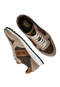 Bruine en beige suède sneakers met witte veters, zwarte rubberen zool en bruine leren accenten. Heeft een gelaagd ontwerp en het merksymbool.