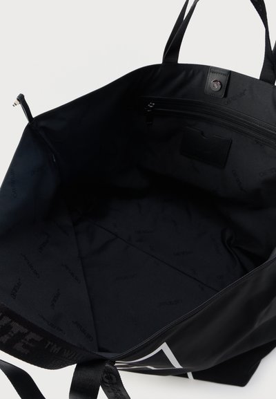 Μαύρη τσάντα tote με ανοιχτό επάνω μέρος, εσωτερική τσέπη με φερμουάρ και υφασμάτινη επένδυση με διακριτικό τυπωμένο μοτίβο λογότυπου της μάρκας.