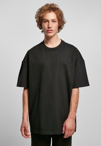 Zwarte oversized t-shirt van katoen, met een ronde halslijn en verlaagde schouders, met een gladde textuur en eenvoudig ontwerp.