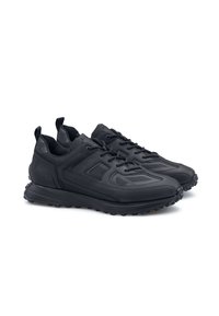 Scarpe sportive nere con una combinazione di materiali lisci e testurizzati, suola in gomma resistente e chiusura con lacci e linguette per il collo.