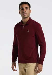 Bordeaux lange mouw polo shirt met een klein logo op de borst, gemaakt van een soepele stof met een kraag en een drieknops sluiting.