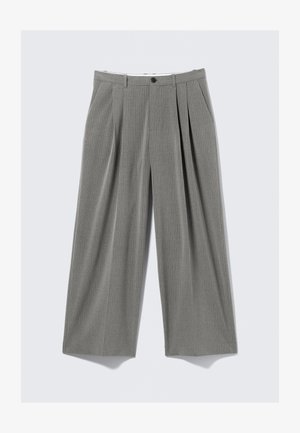 Sive hlače nabrane u nabore s vertikalnim uzorkom tankih pruga, s kopčanjem na gumb, bočnim džepovima i širim krojem nogavica.