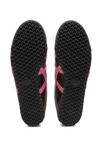 Black and pink sneaker soles feature a textured rubber bottom with a diamond pattern, branding at the heel, and smooth edges.
