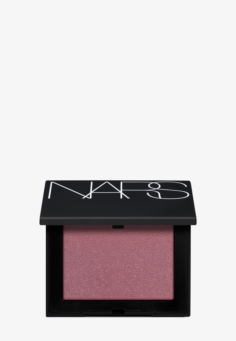 Boîtier noir NARS ouvert présentant un blush poudre rose scintillant sur un fond blanc uni.