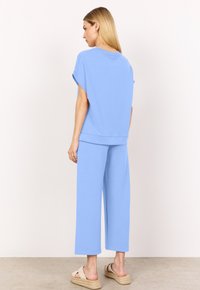 Set di abbigliamento da casa blu chiaro realizzato in tessuto morbido, con una maglietta morbida a maniche corte e pantaloni a gamba larga con vestibilità rilassata.