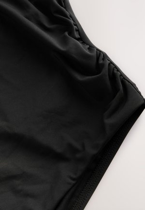 Černé plavecké kraťasy vyrobené z hladkého, lehkého materiálu. Mají nařasené detaily v pase a kontrastní texturovaný lem.