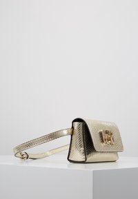 Kullanışlı kapama özelliğine sahip, dokulu bitişe sahip altın metalik çanta. Askısı metalik ve ayarlanabilir.