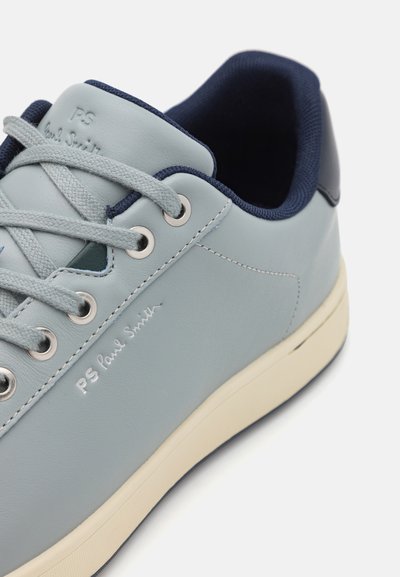 Hellblaue Ledersneaker mit silbernen Ösen, grauen Schnürsenkeln und einem navyfarbenen, gepolsterten Kragen. Mit geprägtem "PS Paul Smith" Branding.