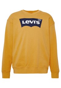 Felpa gialla in cotone con collo rotondo, caratterizzata da un logo blu di Levi's sul fronte. Presenta polsini e orlo a coste.