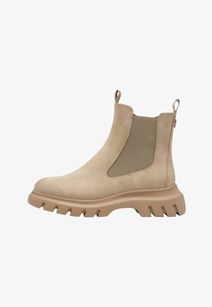 Bottines Chelsea en daim beige avec des panneaux élastiques sur les côtés, une semelle en caoutchouc épaisse et des languettes de traction pour un enfilage facile. Texture lisse avec des détails cousus.