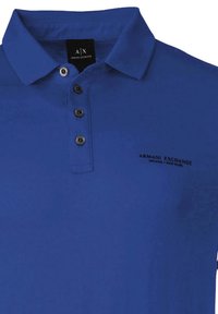 Modrá polo košeľa z bavlny, s klasickým golierom, tromi čiernymi gombíkmi a vyšitým logom na ľavej hrudi.