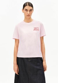 Rosa Baumwoll-T-Shirt mit Rundhalsausschnitt und kurzen Ärmeln, vorne mit rotem Schriftzug "Made to make a difference".