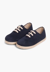 Scarpe in suede blu navy con lacci beige, punta tonda e suola in stile juta per supporto e comfort. Texture liscia con design minimalista.