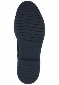 Suela de zapato de goma negra con surcos horizontales para tracción, que presenta un logotipo en relieve y marcas de tamaño. Textura suave con una parte delantera redondeada.