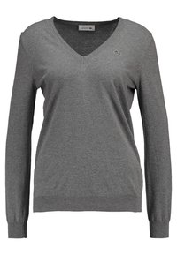 Pull Lacoste gris à manches longues et col en V, avec des poignets et un ourlet côtelés, arborant un petit logo crocodile brodé sur la poitrine gauche.