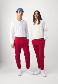 Lacoste SUBTLE LOGO TRACKPANT UNISEX  - Treningo apatinė dalis - ora
