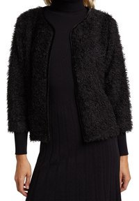 Svart fluffig cardigan i texturerad väv med lös passform, öppen front och trekvartsärmar, lager på lager över en svart polotröja klänning.