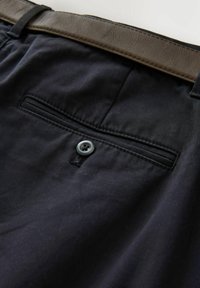 Čierne bavlnené nohavice s hladkou textúrou, s jednou zadnou vreckom so šedým gombíkom a hnedým koženým opaskom s jemným leskom.