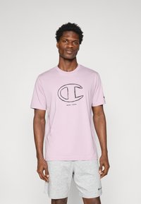 Hellblaues Baumwoll-T-Shirt mit einem schwarzen Logo und dem Text "NEW YORK" zentral auf der Vorderseite. Kurzärmelig und mit Rundhalsausschnitt.