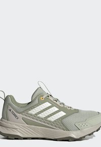 Ανοιχτοπράσινο παπούτσι trail running Adidas Terrex με λευκές ρίγες, μαλακή σόλα και υφή για καλύτερη πρόσφυση σε υπαίθριες δραστηριότητες.