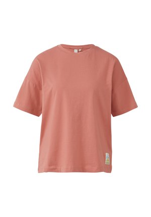 Loose-fit, short-sleeved t-shirt in soft coral cotton. Features a rounded neckline and a small, colorful logo patch on the lower side.