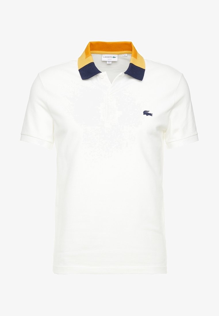 Polo blanc à manches courtes avec col jaune et bleu marine et petit logo crocodile bleu marine sur la poitrine gauche.