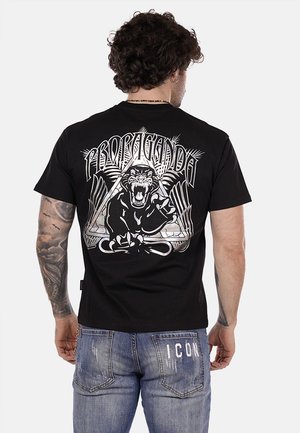 T-shirt in cotone nero con una grande grafica bianca di un pantera che ringhia e il testo "PROPAGANDA" con accenti geometrici sul retro.