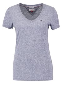 Grå t-shirt med v-hals i mjuk bomullsblandning. Kort ärm, svag textur, med subtil branding på bröstet. Storleksmärkning synlig inuti.