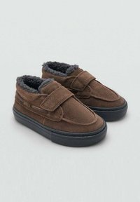 Zapatos de velcro marrones de ante, con un forro de felpa gris, puntera redondeada y suela de goma negra con sutiles detalles de costura.