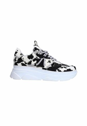 Sneakers with a thick white sole, featuring a black and white cow print pattern and textured fur-like material on the upper. Silver accents visible.