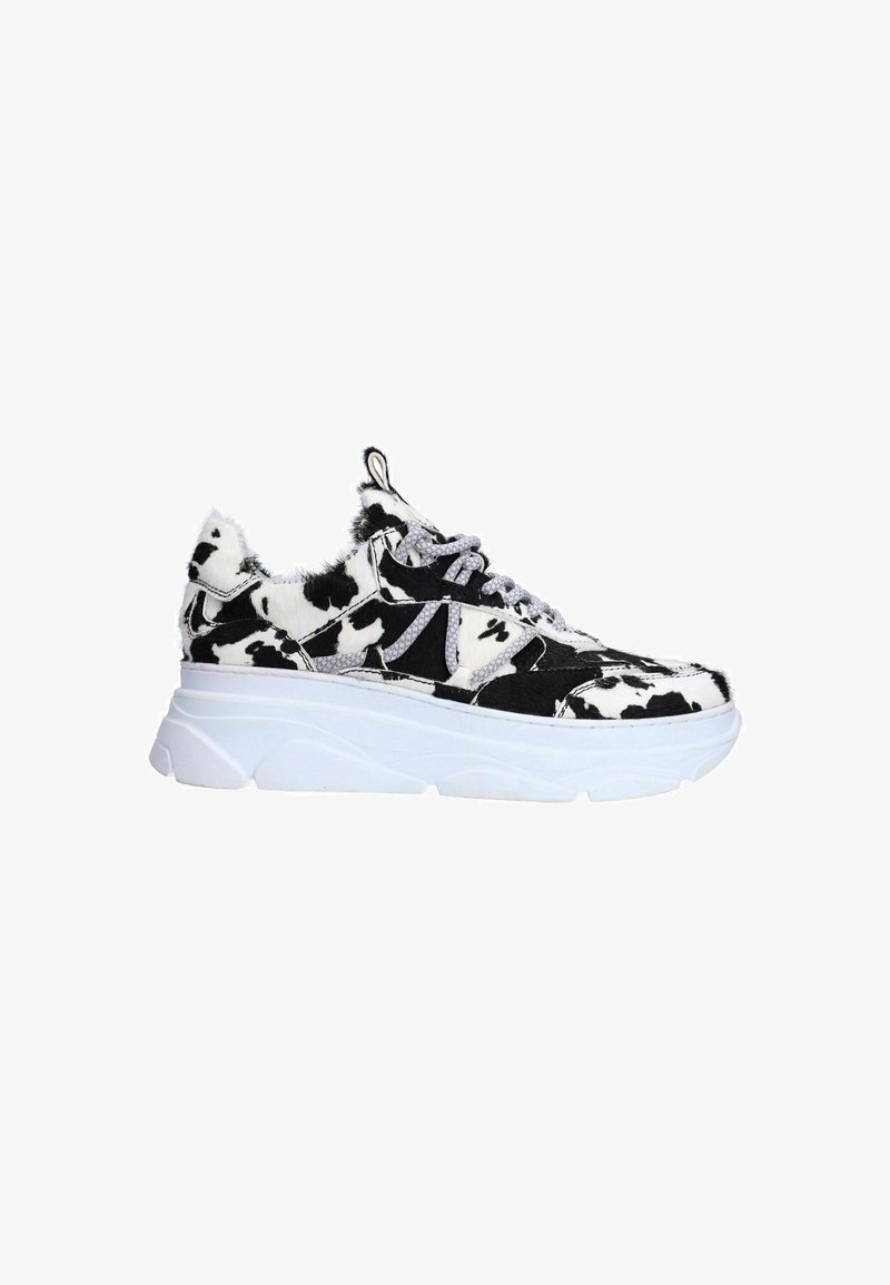 Sneakers with a thick white sole, featuring a black and white cow print pattern and textured fur-like material on the upper. Silver accents visible.