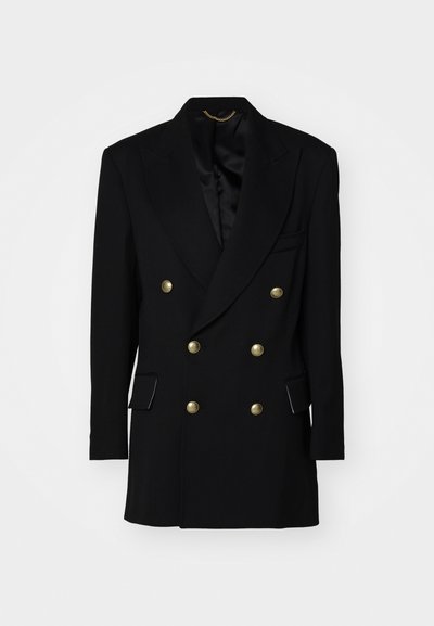 Double-breasted black blazer with gold buttons, satin lapel, two front pockets, structured shape, and sleek fabric texture.