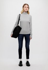 Hallhalli hall; stiilne disain; tume sinine teksad; must tekstuuriga käekott; mustad kingad paksude tallaga; minimalistlik stiil lihtsa taustaga.