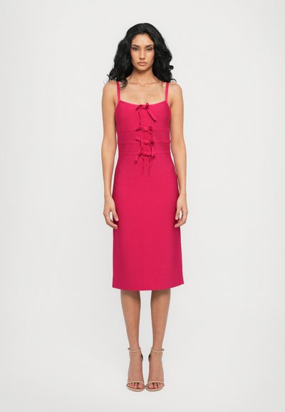 Robe sans manches rose au design ajusté, avec un détail de nœud à l'avant, une longueur au genou et un tissu lisse.