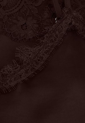 Vêtement marron foncé avec une bordure en dentelle complexe le long du bord, présentant une texture douce et des détails subtilement effilochés.