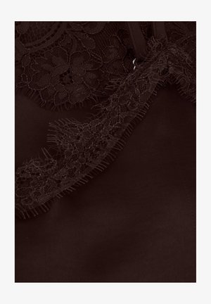 Vêtement marron foncé avec une bordure en dentelle complexe le long du bord, présentant une texture douce et des détails subtilement effilochés.