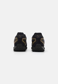 Black and gold athletic shoes with a suede and mesh upper, textured outsole, and a padded collar. Features a contrasting logo and sleek design.